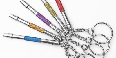 Vijf metalen sleutelhangers met gekleurde cilindervormige gripgedeelten in waaiervorm gerangschikt